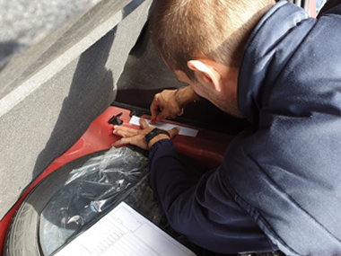 Engineer makes etching of stamped VIN number on Kia Picanto Engineer making etching